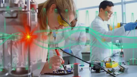 Female scientist soldering PCB in lab while waveforms pulsing and reactor glow Stock Footage 311505730