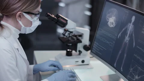 Female scientist studying brainwave scanning and human skeleton Video stock 149800327
