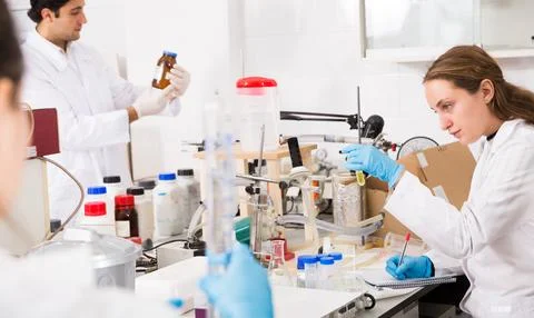 Female scientist taking notes in test chart Foto stock