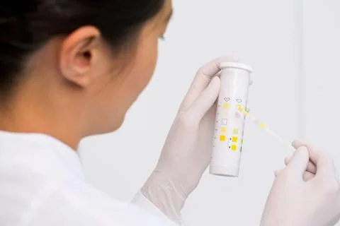 Female scientist testing urine sample Stock Photos