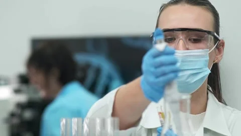 Female scientist using a micropipette for analysis in a modern laboratory. Видео 269286798