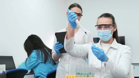 Female scientist using a micropipette for analysis in a modern laboratory. Видео 269310939