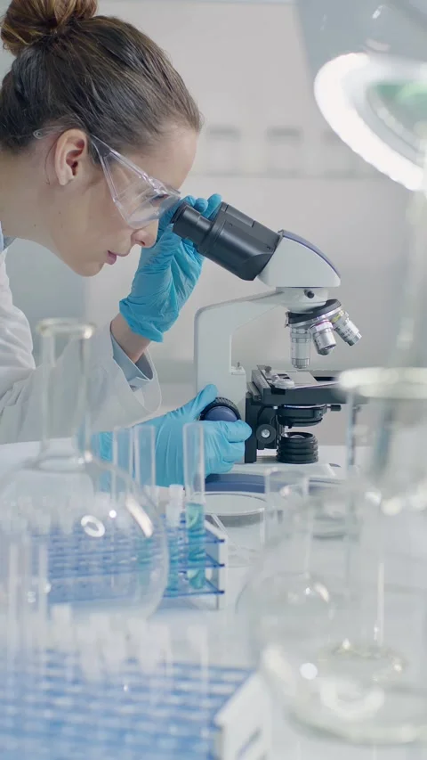 Female Scientist Using Microscope in Laboratory Stock Footage 327020069