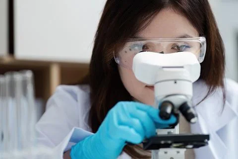 Female Scientist Using Microscope in Laboratory for Scientific Research and Stock Photos