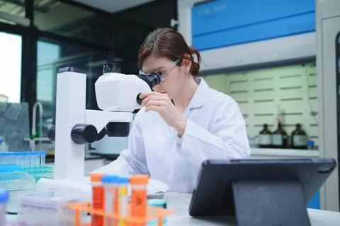 Female Scientist Using Microscope in Modern Laboratory Фото