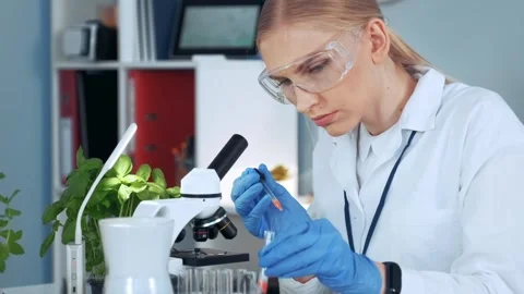 Female scientist using pipette in laboratory research facility Stock Footage 340983469