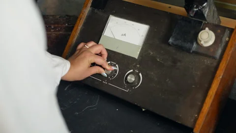 A female scientist using a vintage fluorometer. The woman is turning knobs 動画素材 249741379
