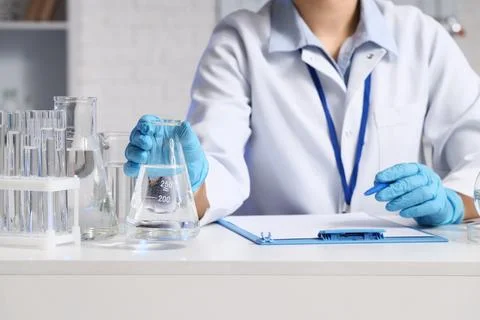 Female scientist with water samples at table in laboratory, closeup Stock Photos