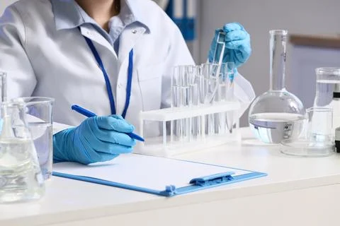 Female scientist with water samples at table in laboratory Stock Photos