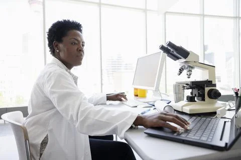 Female scientist working at computer and laptop in laboratory Stock Photos
