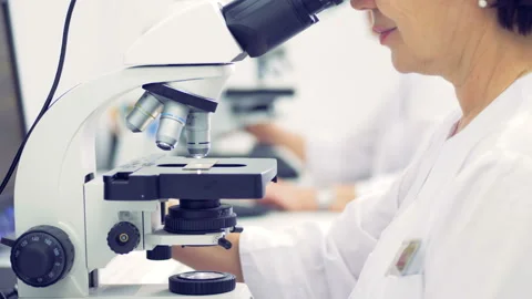 A female scientist is working in a laboratory with a microscope Stock Footage 87820203