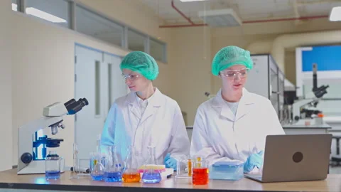 Female scientists analyzing research data on a laptop in a laboratory Stock-Footage 346938650