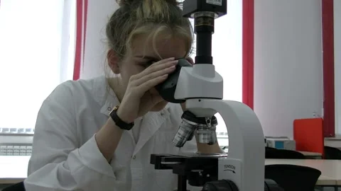 Female scientists in laboratory looking through a microscope Stock Footage 85508785