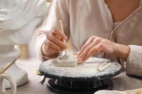 Female sculptor making figure at table in workshop, closeup Stock Photos