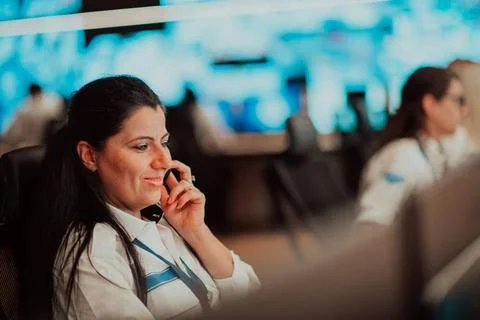 Female security guard operator talking on the phone while working at works... Foto stock