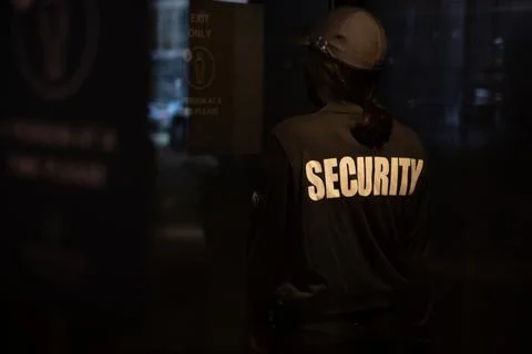 Female security guard walking through an automated revolving curved sliding door Stock Photos