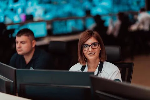 Female security operator working in a data system control room offices Technical Foto stock
