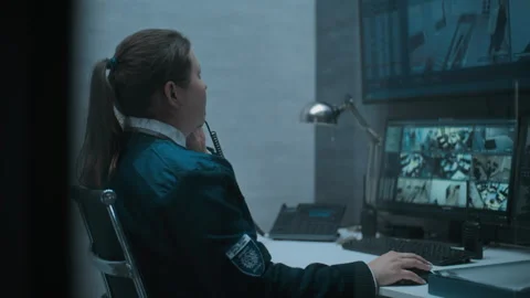 Female security worker or dispatch works on computer with CCTV cameras Stock Footage 281719499