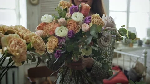 Female self employed florist is picking flowers for bouquet in vintage workshop Stock Footage 149131184