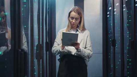 Female server specialist in data center using tablet checking working system of Stock Footage 119083396