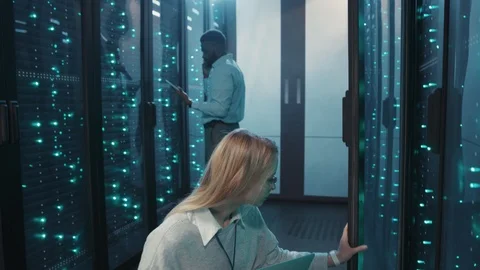Female server technician running diagnostics on notebook inspecting rack Stock Footage 119082514