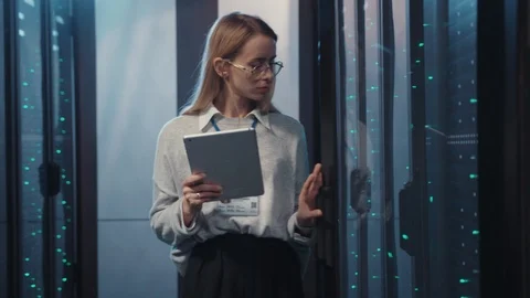 Female server technician using tablet inspecting rack server computers system Stock Footage 119083318