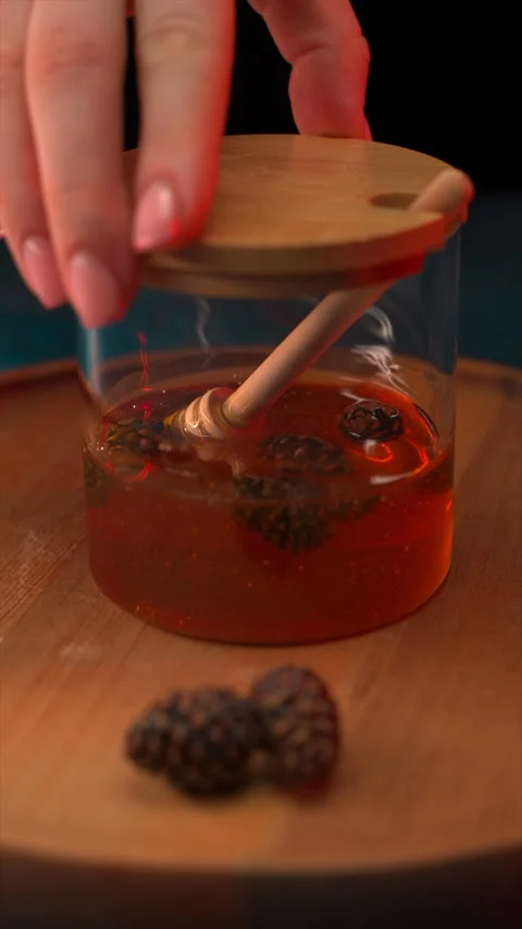 Female Setting Down Honey Jar on Table in Muted Ambiance Stock Footage 267622761