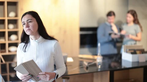 Female shopper carefully selects samples of material for a future kitchen set in Stock Footage 310533902