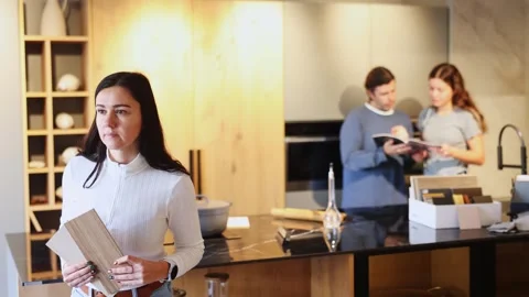 Female shopper carefully selects samples of material for a future kitchen set in Stock Footage 322112989