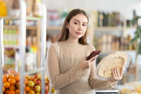 Female shopper scans QR code on pizza with smartphone Stock-Fotos