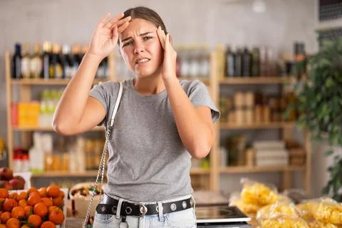Female shopper suffers from headache while shopping at supermarket Stock Photos