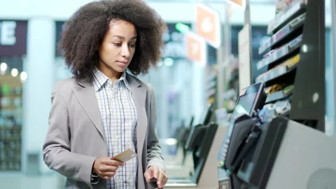 Female shopper using a self-service cashier checkout in a supermarket. Customer  Stock Footage 255147404
