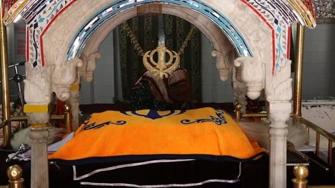 A female Sikh devotee praying inside Gurdwara Panja Sahib Stock Footage 86660515