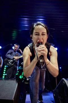 Female singer performs onstage during blue sound check with dramatic light Stock Photos