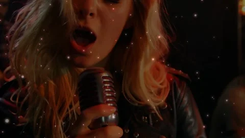 Female singer placing mic singing guitarist strumming sparks floating over Stock Footage 331214530