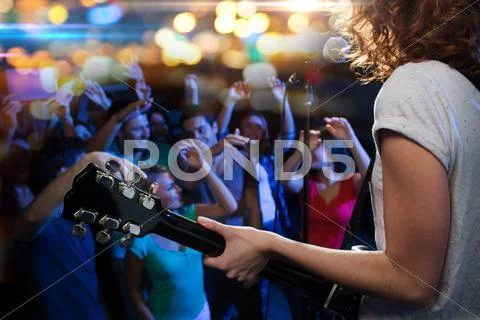 Female Singer Playing Guitar Over Happy Fans Crowd