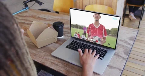 Female sitting cafe table watching laptop soccer feed with camera shifting, Stock Footage 339767529