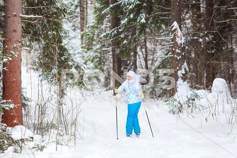 Female skier turning back skiing in winter forest Stock Photos