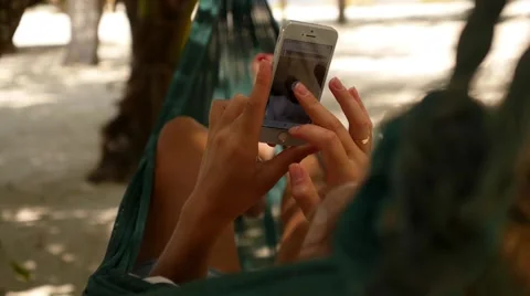 Female with Smartphone in Beach Hammock. Vídeo Stock 42667149