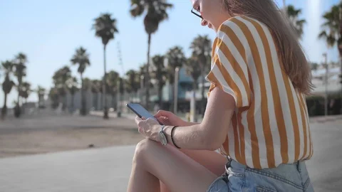 Female with smartphone chat or scrolling network application or app in summer Stock Footage 100302652