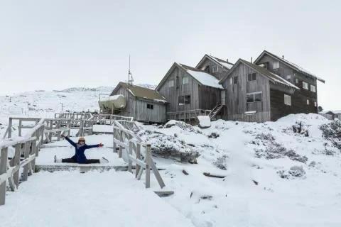 Female smiling at camera and doing the splits in the snow Tasmania, Australia Stock Photos