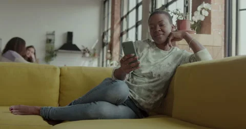Female on Sofa looking at Smart phone in Loft Apartment Stock Footage 237744291