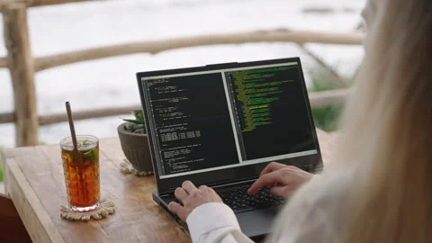 Female soft dev with laptop on remote work day in tropical cafe. Software Stock Footage 248681050