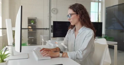 Female Software Developer Coding at Desktop Computer in Modern Bright Office Stock-Footage 348010880