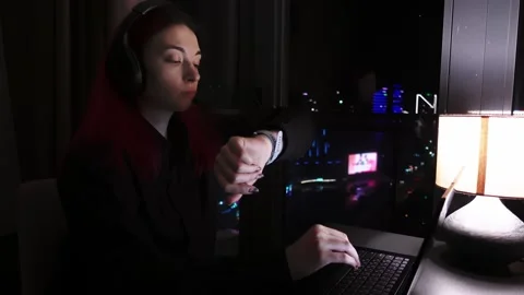 Female software developer is engrossed in programming as city glow illuminates 스톡 동영상 343951016
