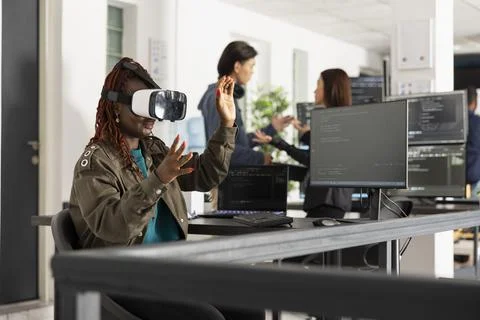 Female software developer exploring virtual reality in modern office Foto stock