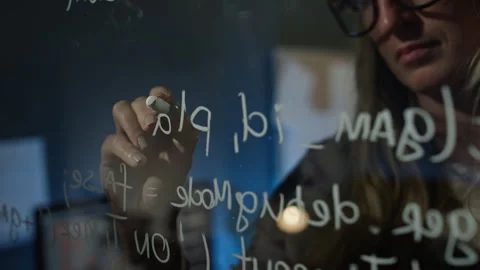 Female Software Developer Writing Code on Glass Wall in Office at Night Stock Footage 273833649
