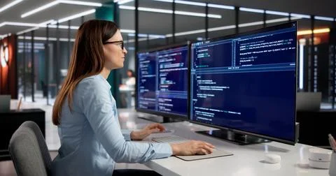 Female Software Engineer Deeply Engaged In Coding On Desktop Computer Stock Photos