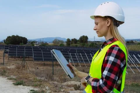 Female solar engineer reviewing data on a tablet, ensuring the efficient op.. Stock Photos