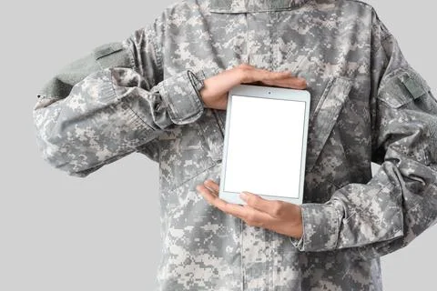 Female soldier with blank tablet computer on light background, closeup Stock Photos